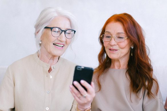 Financial Scams. Two elderly women looking at a mobile phone.