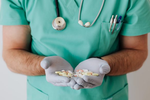 Vitamin D Faceless doctor with pills on hand.